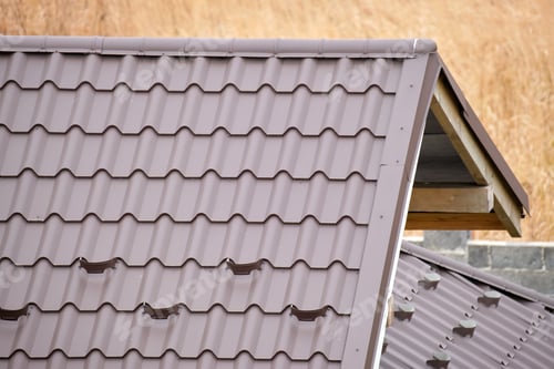 Preview: Closeup snow guard for safety in winter on house roof top covered with steel shingles.