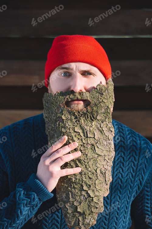 Preview: portrait of man with beard made of wood bark looking at camera outdoors