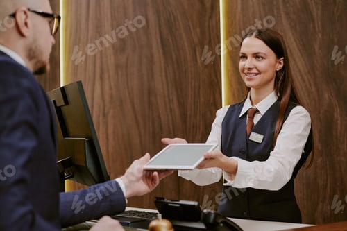 Preview: Receptionist Giving Tablet to Hotel Guest