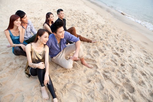 Preview: Happy young people sitting on the beach of Repulse Bay, looking at view, Hong Kong