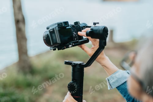 Preview: Concentrated senior woman arranging and preparing to record with her camera, photos and videos.