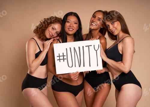 Preview: Group of women in underwear looking at camera and holding banner