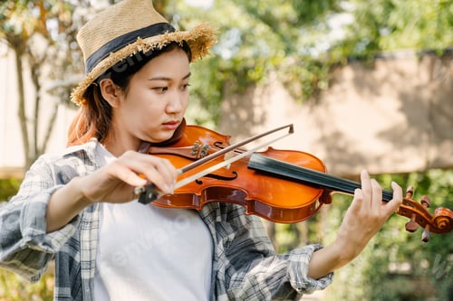 Preview: Close-up portrait of Young Asia woman music violinist play the violin, relax in the garden