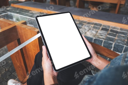Preview: Mockup image of a woman holding digital tablet with blank white desktop screen in cafe