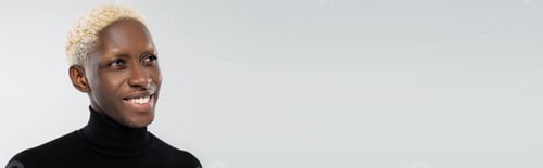 Preview: portrait of happy african american man with heterochromia isolated on grey, banner
