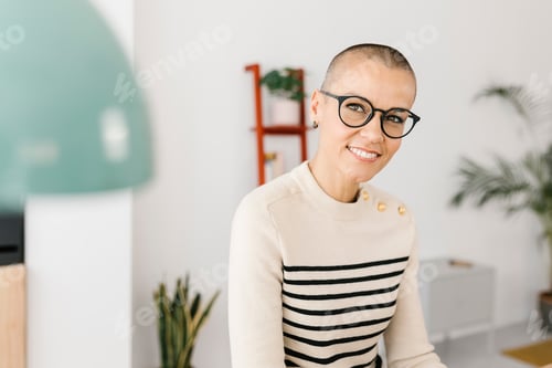 Preview: Successful mid adult business woman sitting on desk at home office