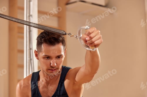 Preview: Pilates instructor performing fitness exercise on cadillac equipment, at the gym indoor.