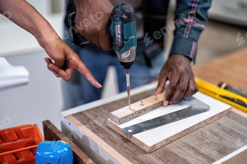 Preview: In wooden industrial senior carpenter teach trainee engineer use power tool drilling screw to wood