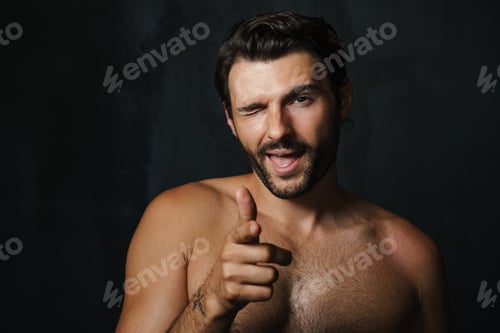 Preview: Young half-naked man winking while pointing finger at camera
