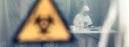 Preview: Scientist investigating in the laboratory behind a protective curtain