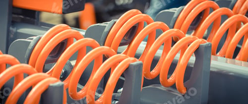 Preview: Big and hard orange steel spring as part and detail of industrial or agricultural machine