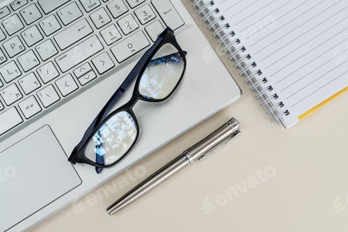 Preview: Top view of a desk with laptop, notebook, pen and glasses
