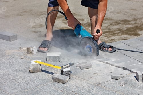 Preview: Hands of the builder cutting granite slabs and paving with a diamond saw