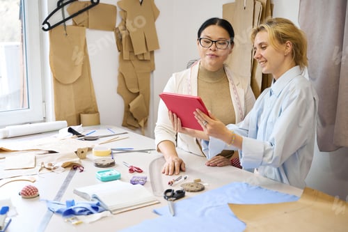 Preview: Colleagues fashion designers use a tablet in a work environment