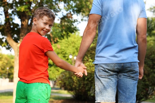 Preview: Little boy and his father holding hands outdoors. Family weekend