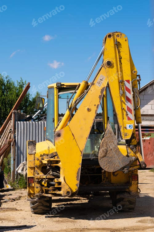 Preview: Grungy old yellow excavator in a construction area