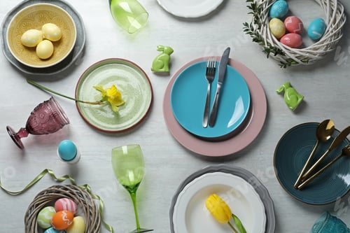 Preview: Festive Easter table setting with painted eggs on wooden background, top view