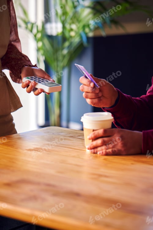 Preview: Close Up Of Man Paying Female Server In Coffee Shop Using Debit Or Credit Card