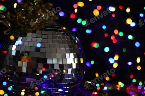 Preview: Disco ball surrounded by colored lights in the background. New Years Eve party celebration