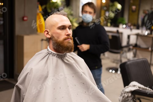 Preview: European brutal man with a beard cut in a barbershop