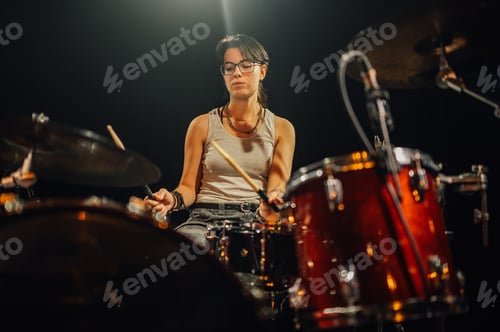 Preview: Female drummer passionately playing drums on stage