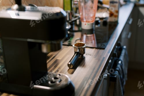 Preview: Cone with poured ground coffee lies on the table near the coffee machine