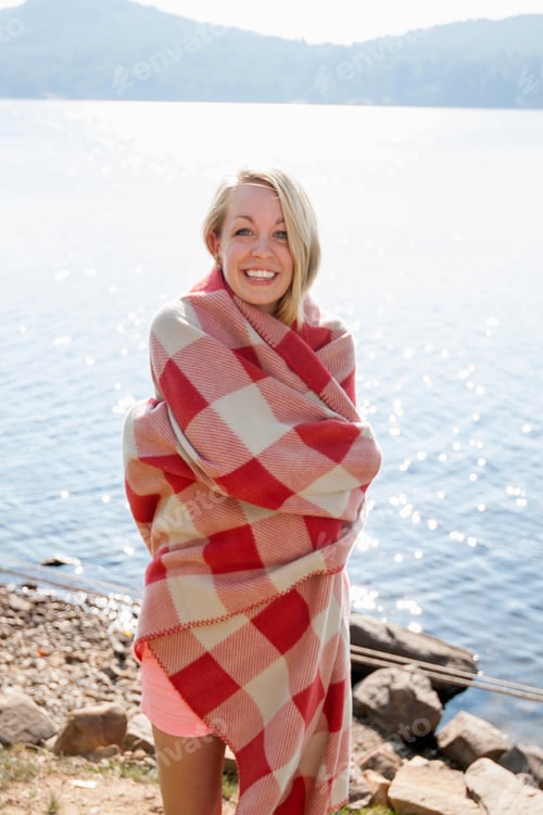 Preview: Young woman wrapped in blanket by lake, Hadley, New York, USA