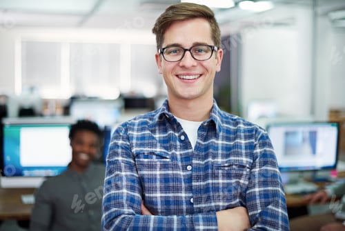 Preview: Portrait of a young man standing in an office with designers in the background