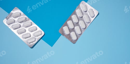 Preview: Oval white pills in a gray blister pack on a blue background, top view.