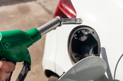 Preview: Close-up of a man's hand with the gun refueling gasoline or diesel fuel in a white car