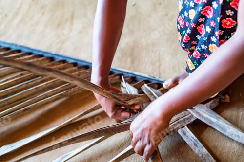 Preview: Woman hands braiding green coconut leaves
