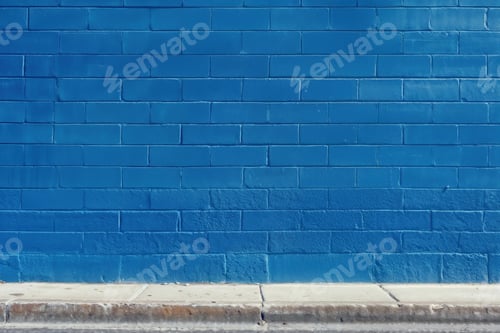 Preview: Bright blue wall with sidewalk on a sunny day in an urban setting