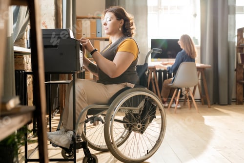 Preview: Businesswoman in Wheelchair Uses Printer in Modern Office