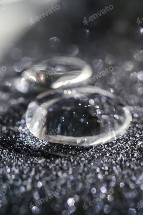 Preview: A drop of cosmetic gel on a black shining background.