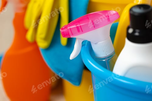 Preview: Various household cleaning detergents and bottles in a plastic bucket on the floor