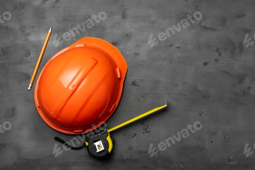 Preview: Orange hardhat, ruler and pencil on black background