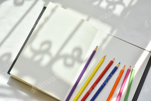 Preview: Color pencils on white notebook background.