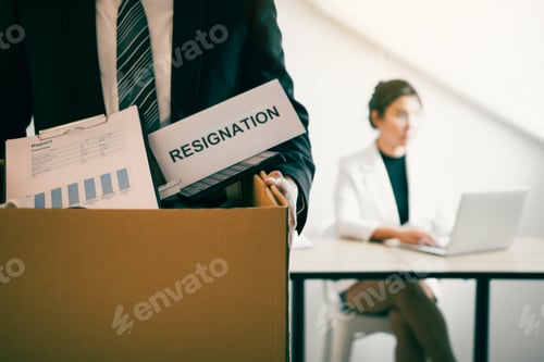 Preview: Front view with the male employee standing holding office supplies in the paper box going to submit