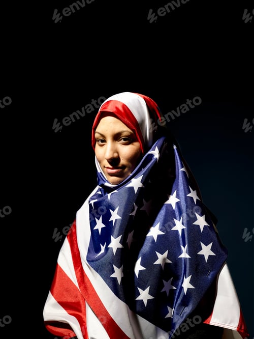 Preview: Woman draped in an American flag hijab looking at the camera with a subtle smile