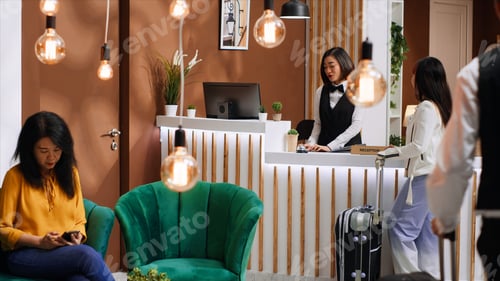 Preview: Young traveler arriving at hotel lobby with luggage