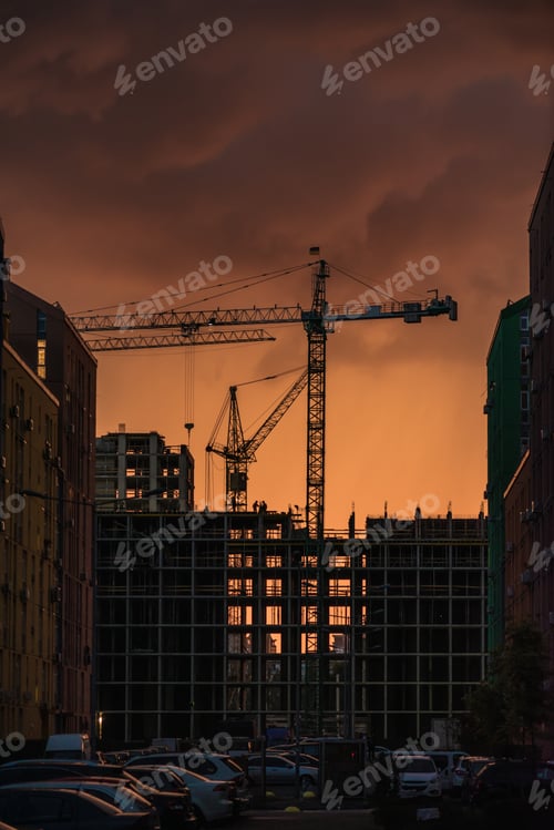 Preview: Industrial construction crane and building silhouettes over sun at sunset