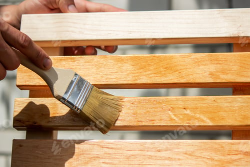 Preview: Painting wooden furniture with varnish. a man hides a tree with varnish.