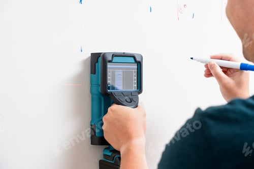 Preview: Worker Using Wall Scanner and Marking Stud Location