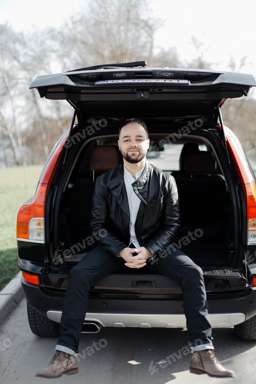Preview: Portrait of fashionable well dressed man with beard posing outdoors