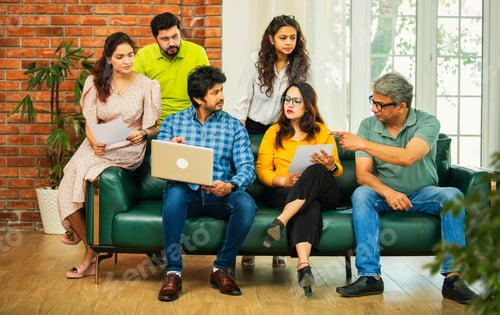 Preview: Young startup team in India planning and discussing ideas together in a modern office setting