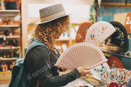 Preview: One woman in shopping leisure activity inside a store touching folding fans for heat temperature