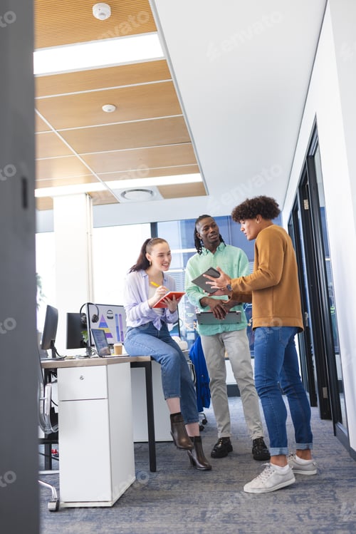 Preview: Diverse group of young colleagues discussing in office