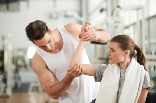 Preview: Sporty woman with elbow pain in gym