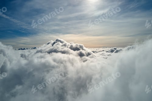Preview: Aerial view from airplane window at high altitude of earth covered with white puffy cumulus clouds