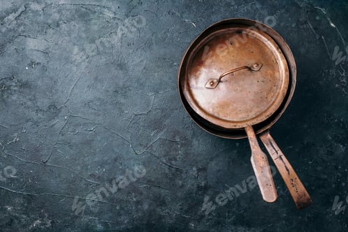 Preview: Old vintage copper pots on dark background. Kitchen utensils. Rustic pan. Top view, copy space for
